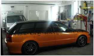 Orange lackiertes Auto im Werkstattbereich